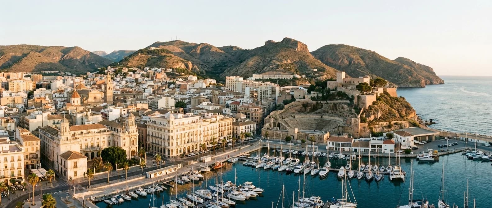 Cartagena med historisk hamn, stadskärna, kullar och Medelhavet i kvällsljus på Costa Cálida