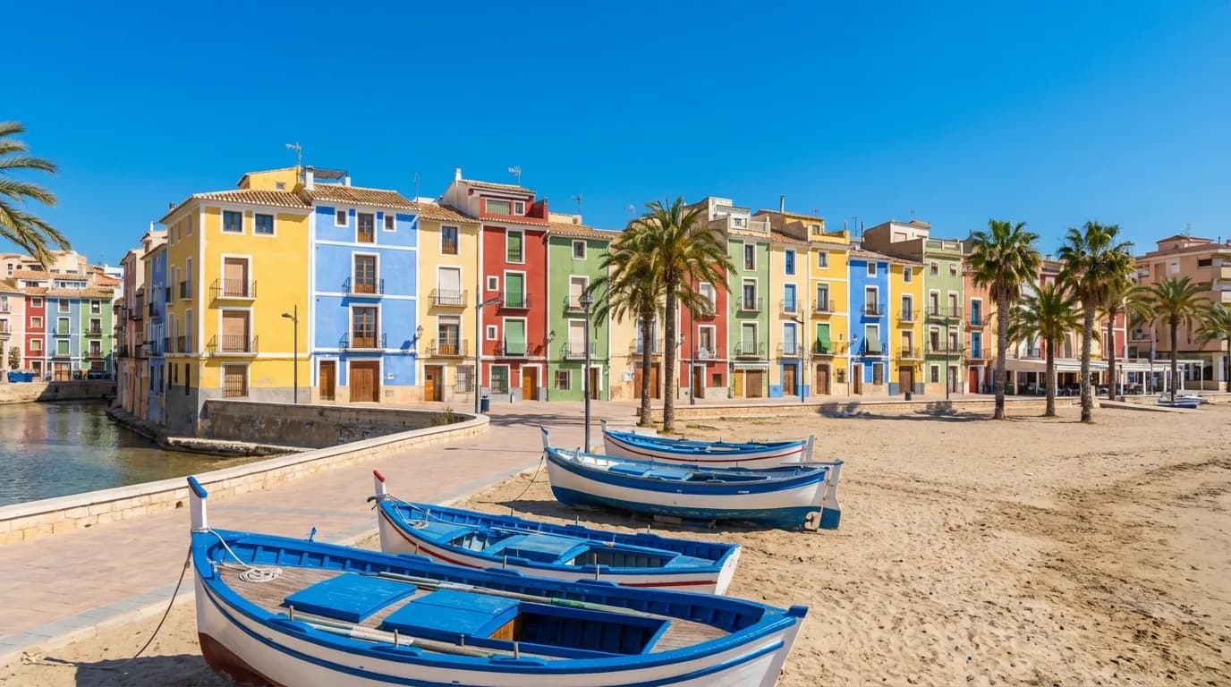 Villajoyosas farggladda fiskarhus langs kusten med gula, bla, roda och grona fasader, Costa Blanca