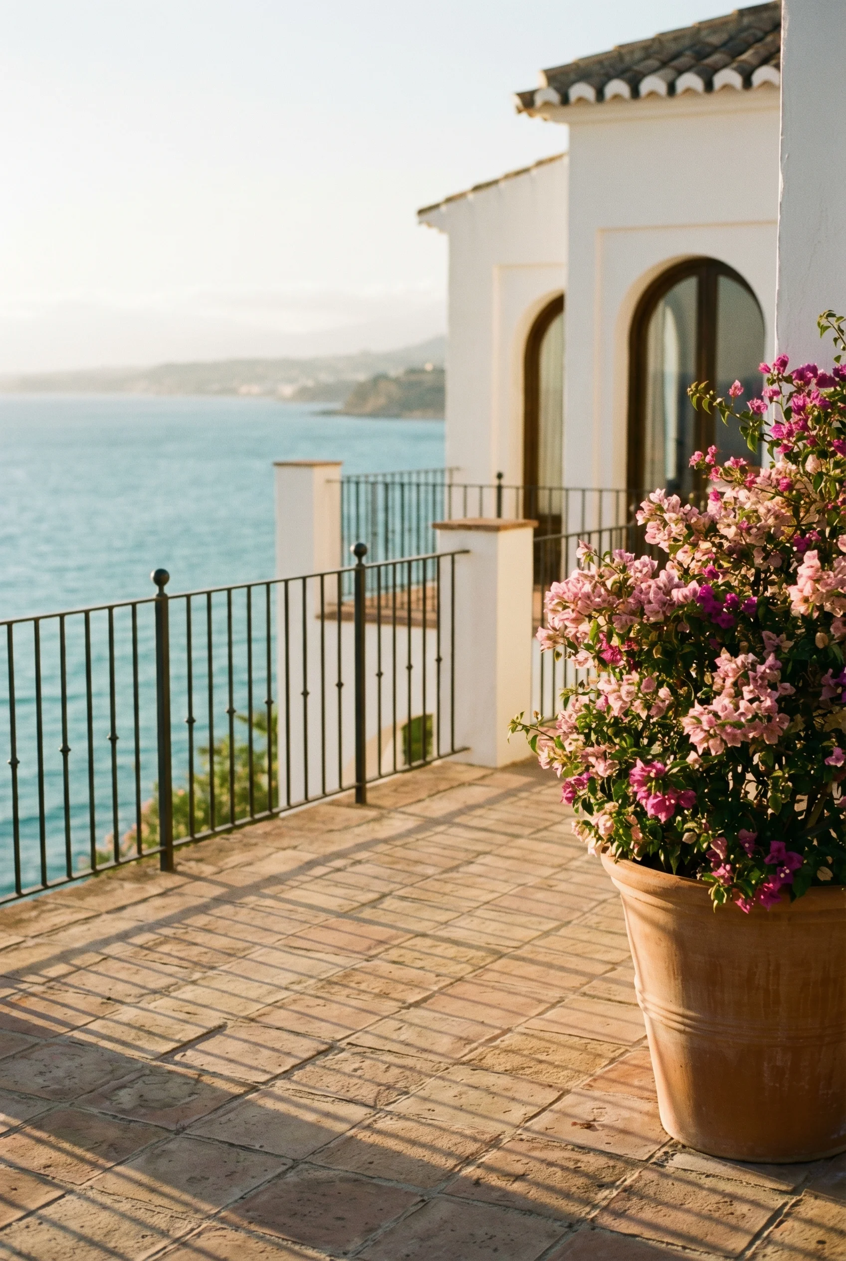 Elegant medelhavsterrass vid gyllene timmen med vy över havet