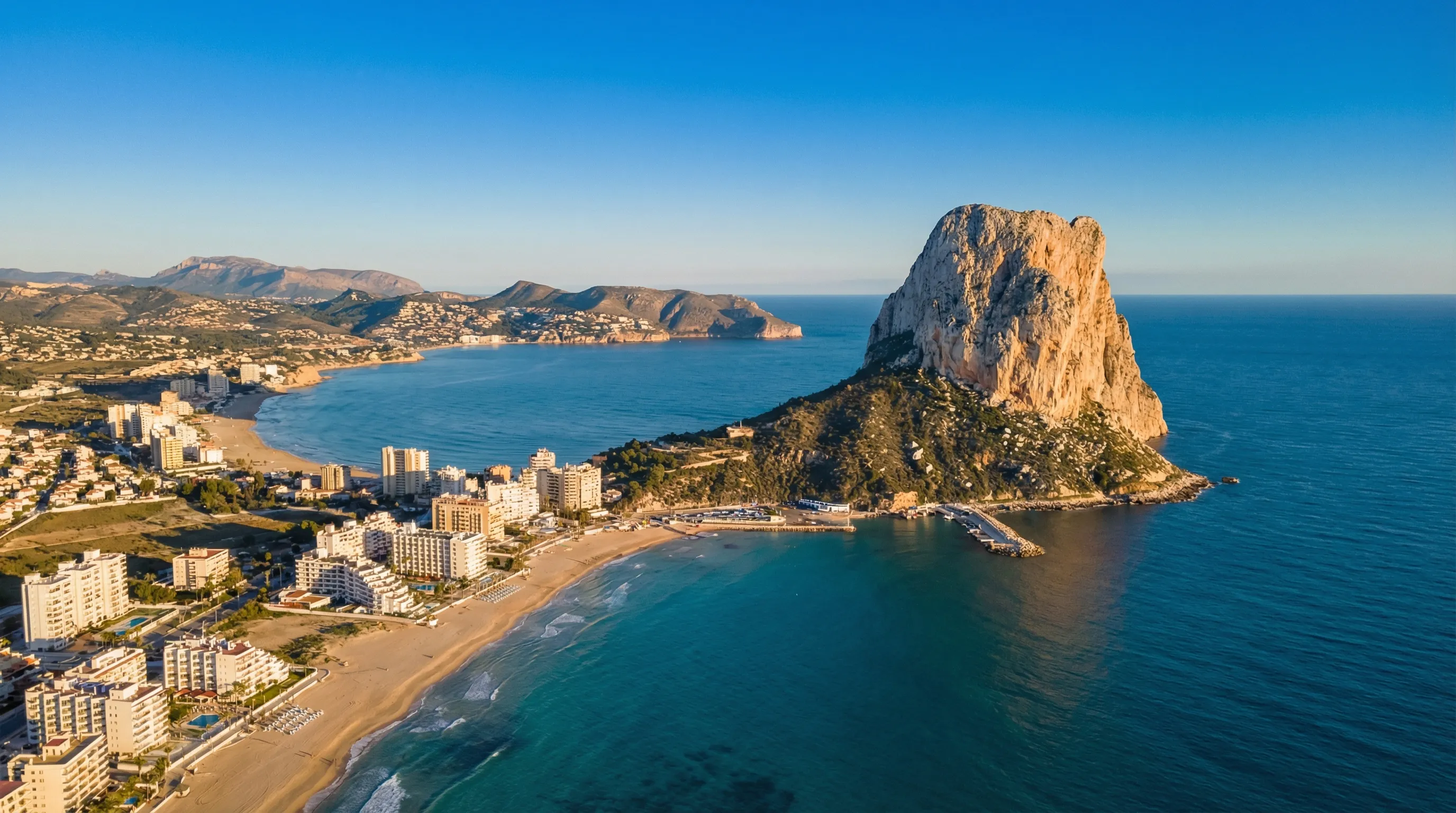Calpes kustlinje med Peñón de Ifach-klippan som reser sig ur Medelhavet, sandstrand och turkost vatten, Costa Blanca